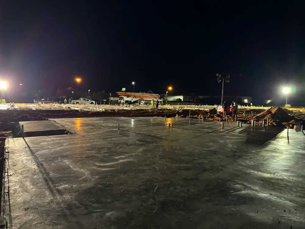A construction site at night with a lot of lights on.