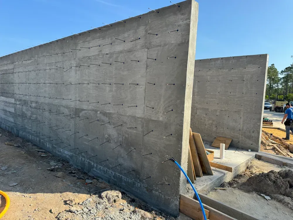 A concrete wall is being built on a construction site.