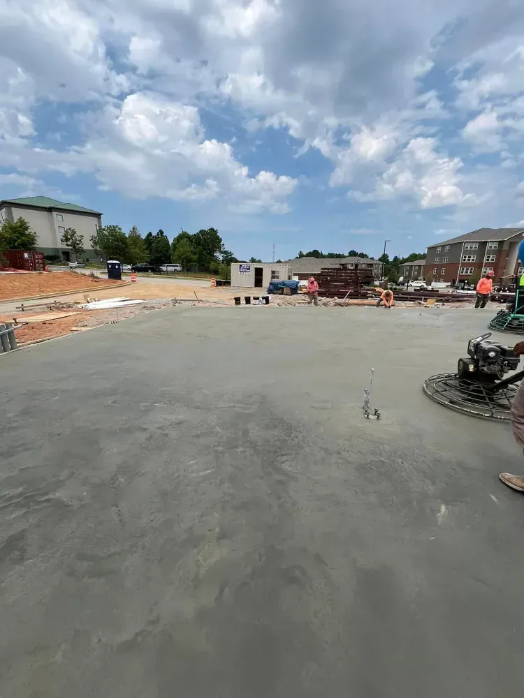A man is using a machine to finish a concrete driveway.