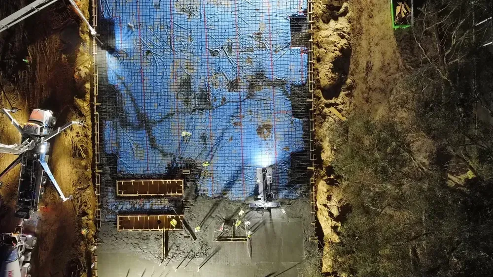 An aerial view of a building under construction at night.