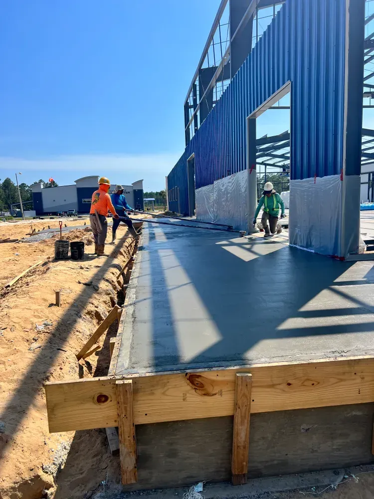 A group of construction workers are standing in front of a building under construction.