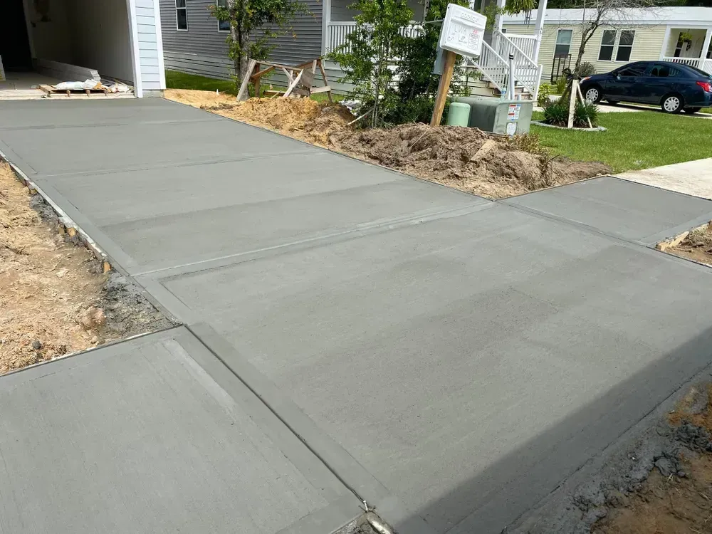 A concrete driveway is being built in front of a house.