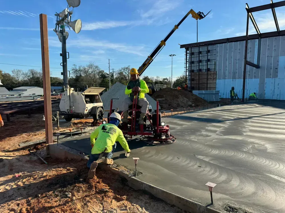 A group of construction workers are working on a concrete floor.