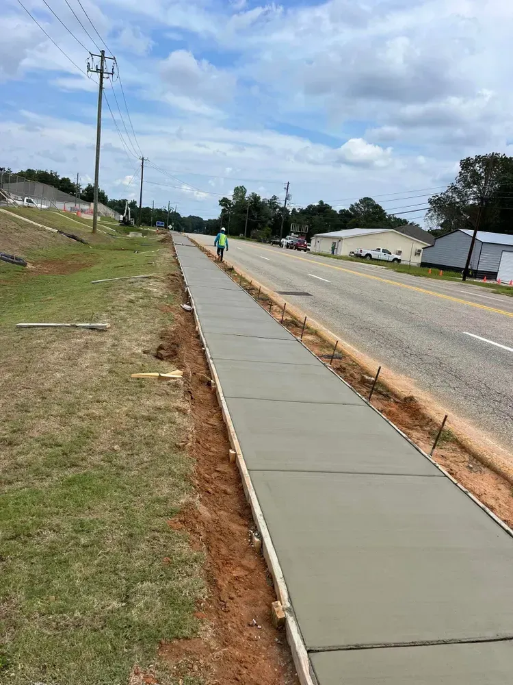 A concrete sidewalk is being built next to a road.