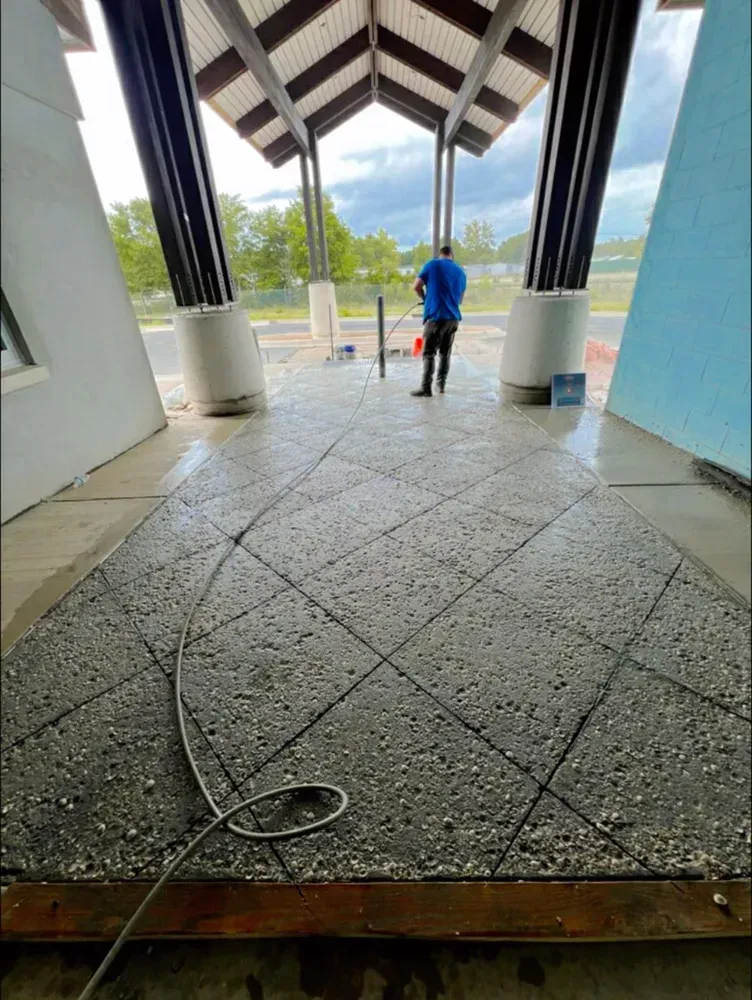 A man is standing on a concrete floor in front of a building.