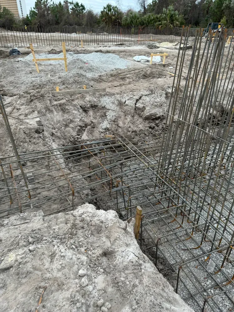 A construction site with a lot of concrete and metal fences.