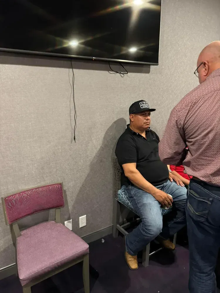 A man is sitting in a chair in front of a television.
