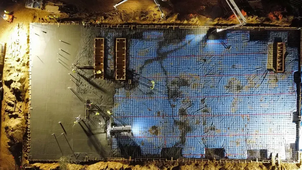 An aerial view of a building under construction at night.