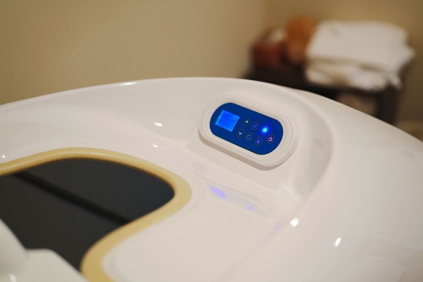 A white toilet seat with a blue remote control on it