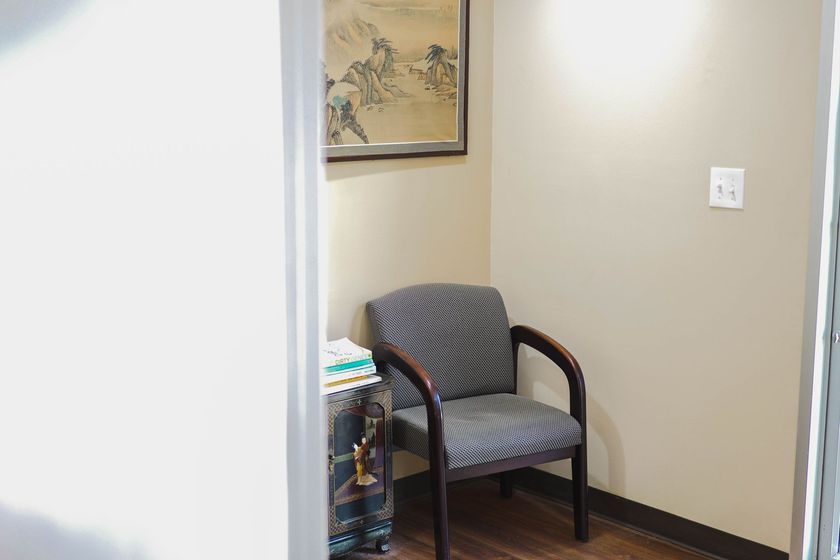 A waiting room with a chair and a picture on the wall.