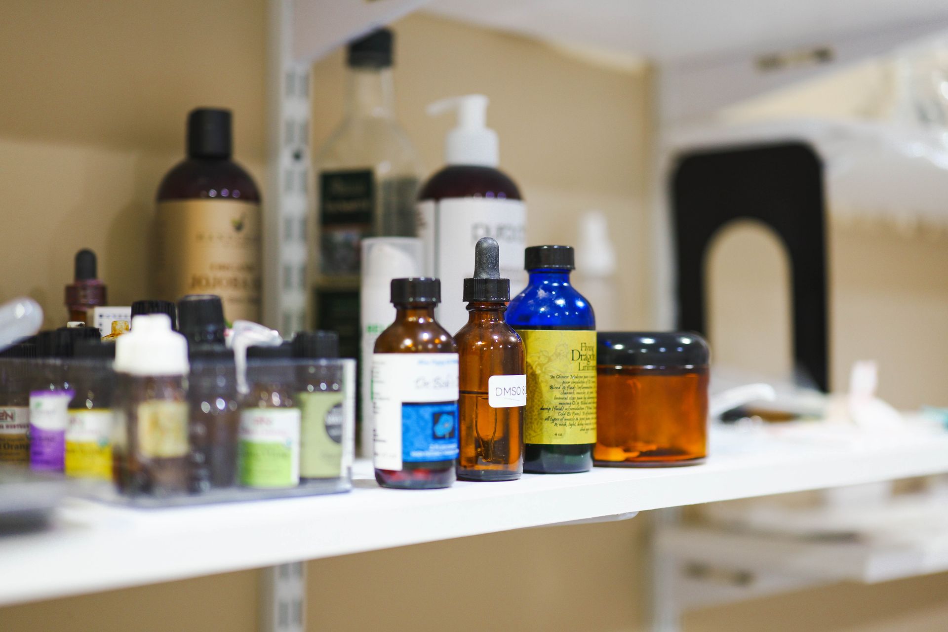 A shelf filled with bottles and jars of herbs and oils for IHP