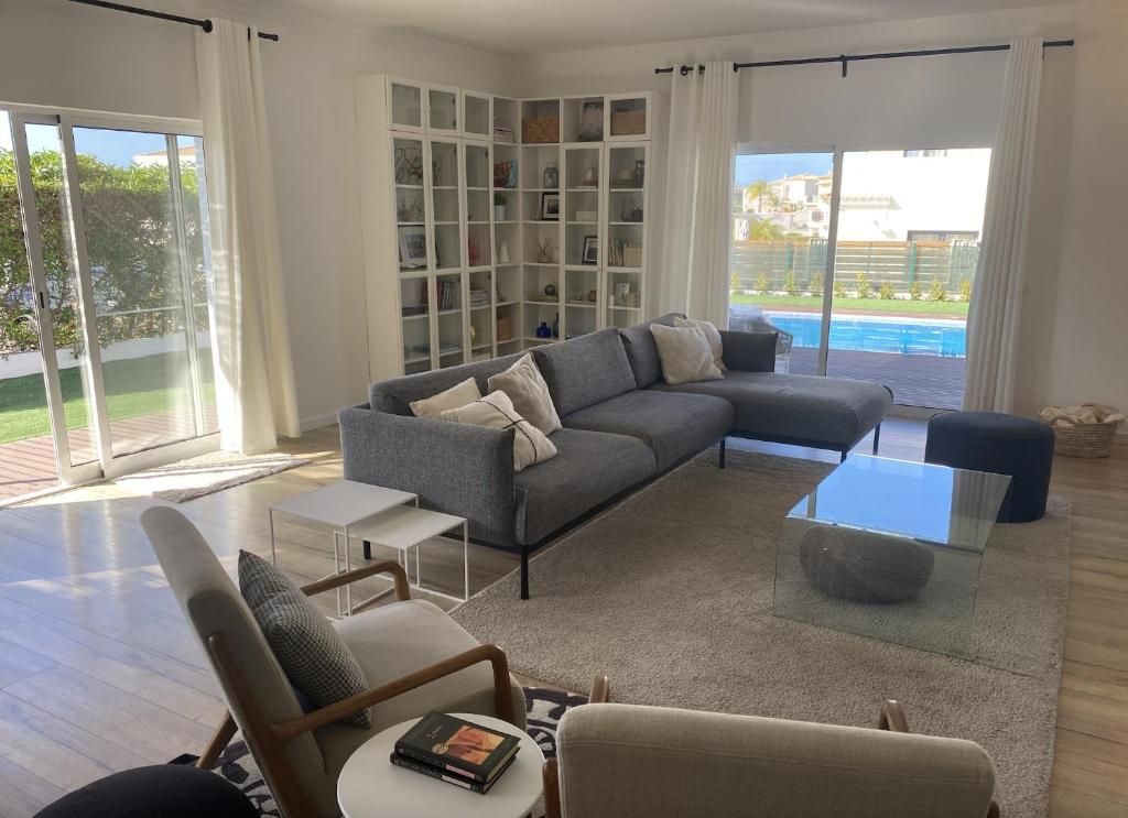 A living room with sofa, chairs and table