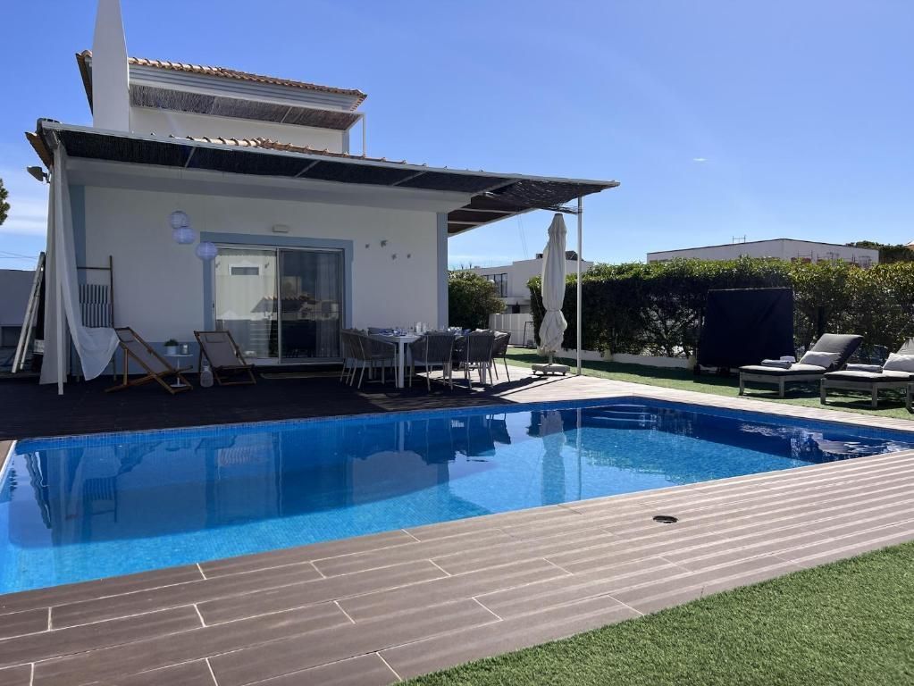 A house with a large pool in front.
