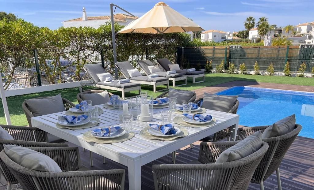 A table and chairs are placed in front of a swimming pool.