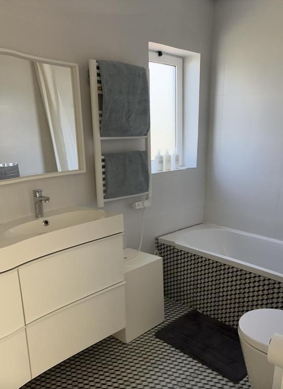 A bathroom with sink, toilet, bathtub and mirror.