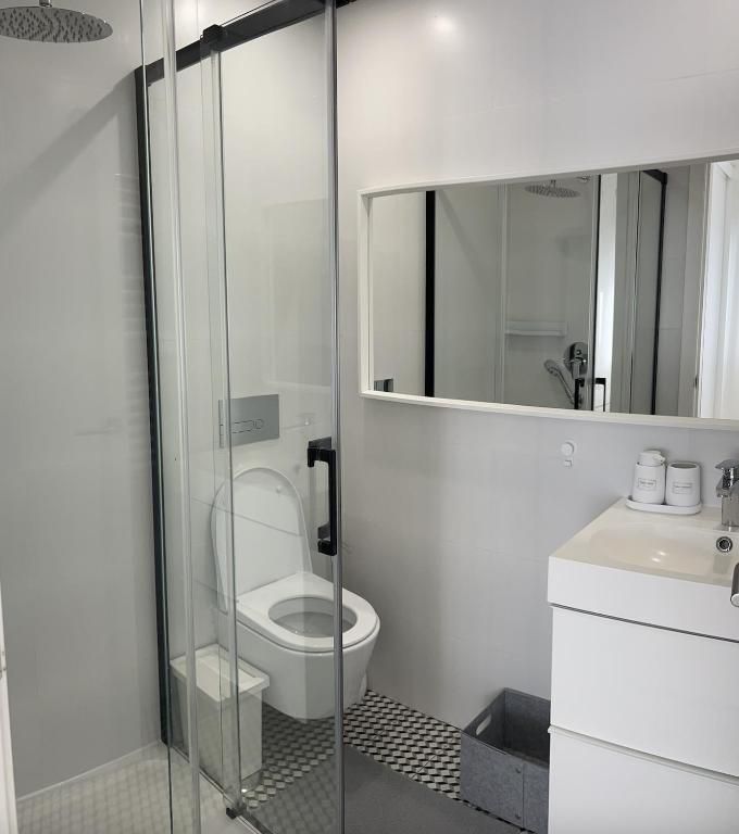 Um banheiro com vaso sanitário, pia e espelho