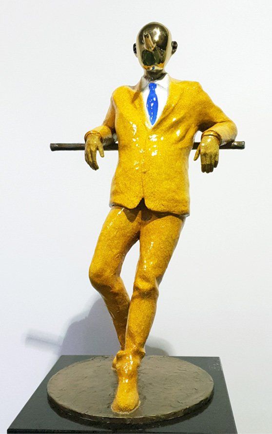 A statue of a man in a yellow suit and tie