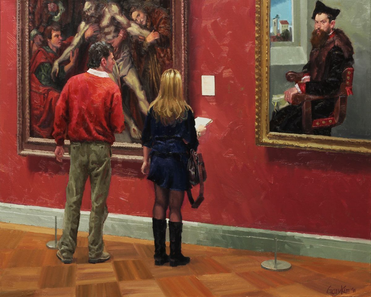 A man and a woman are looking at paintings in a museum.