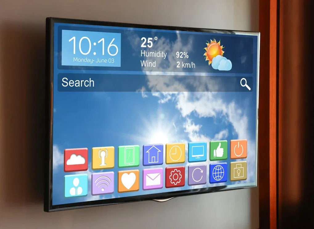 Smart TV home screen with search bar, weather, time, and colorful app icons