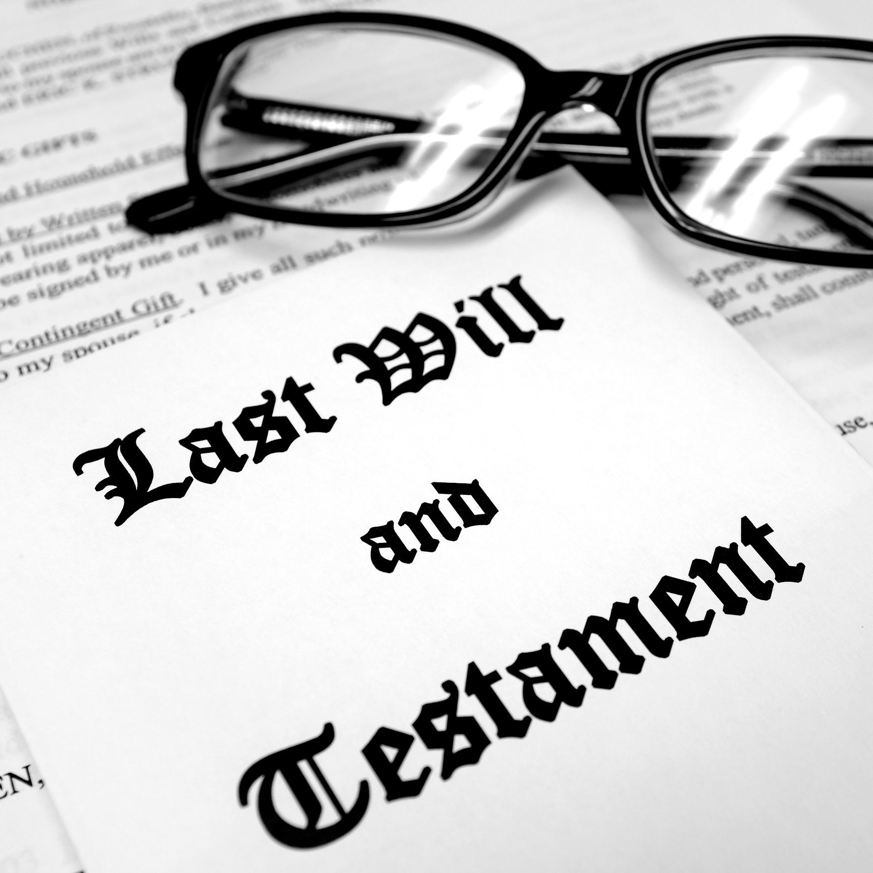 A pair of glasses rests on top of a last will and testament