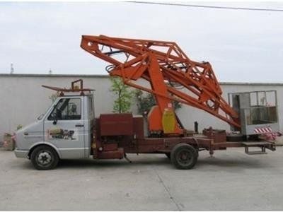 Un autocarro leggero di colore argento dotato di una piattaforma aerea articolata arancione con cestello per il trasporto del personale.