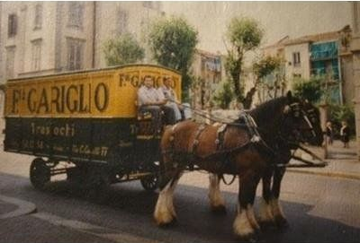 Due cavalli trainano un carro per le consegne con la scritta 