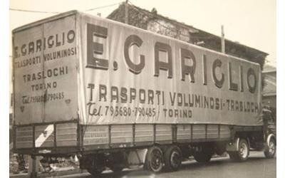Una vecchia foto in bianco e nero di un grande camion per traslochi a Torino con la scritta 