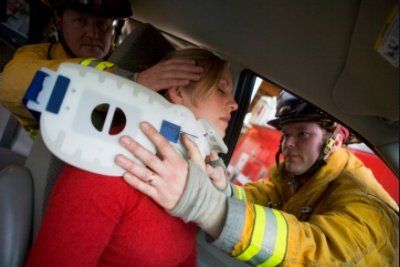 Two firemen helping woman with neck brace - MA,USA