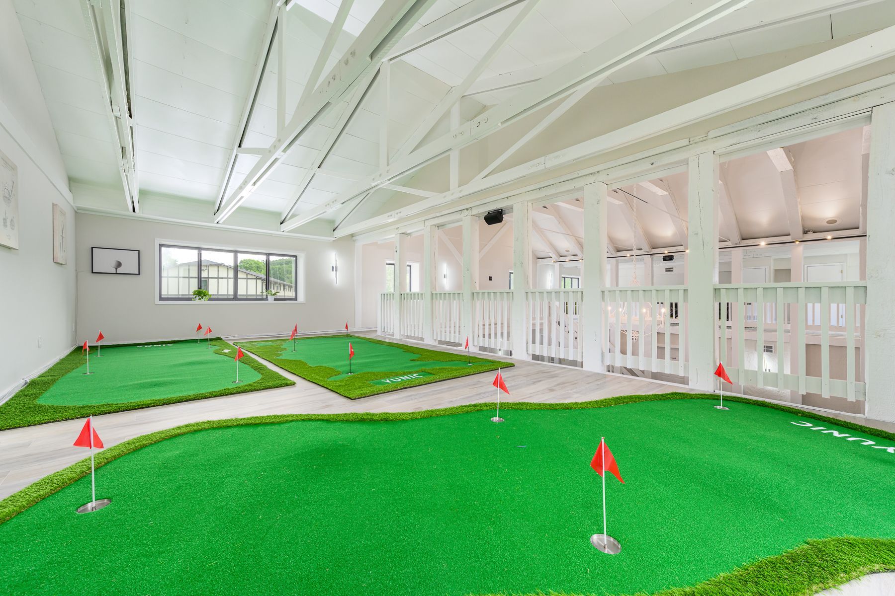A large room with a putting green in the middle of it.