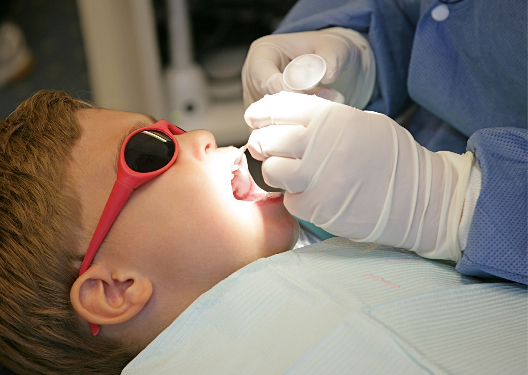 child receiving fluoride treatment at dentist office
