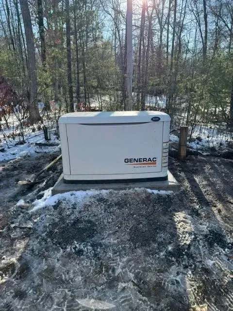A generator is sitting in the middle of a snowy field.