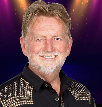 A man with a beard and a black shirt is smiling for the camera.