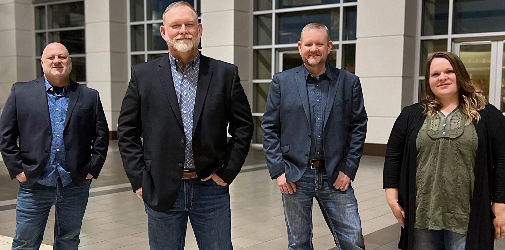 A group of people standing next to each other in front of a building.