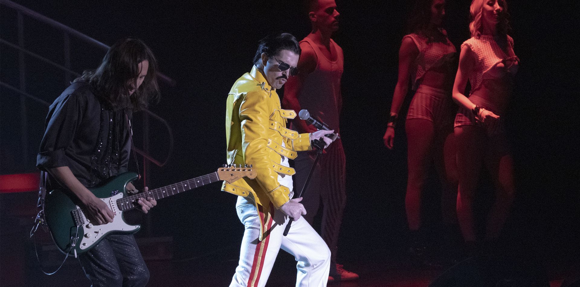 A man is singing into a microphone on a stage.