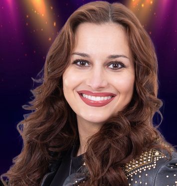 A woman in a silver jacket and choker is smiling for the camera.