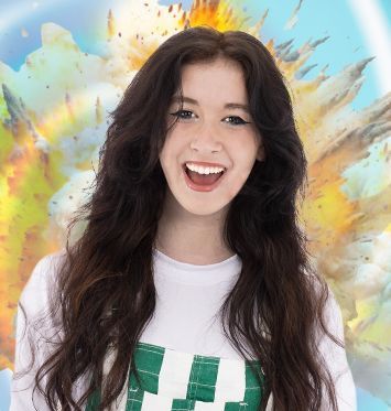 A woman wearing a pink sweater and blue jeans with dinosaurs on them