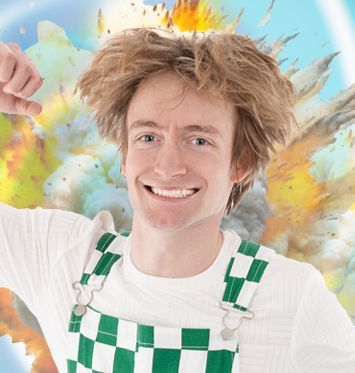 A young man in a blue shirt and green pants is jumping in the air