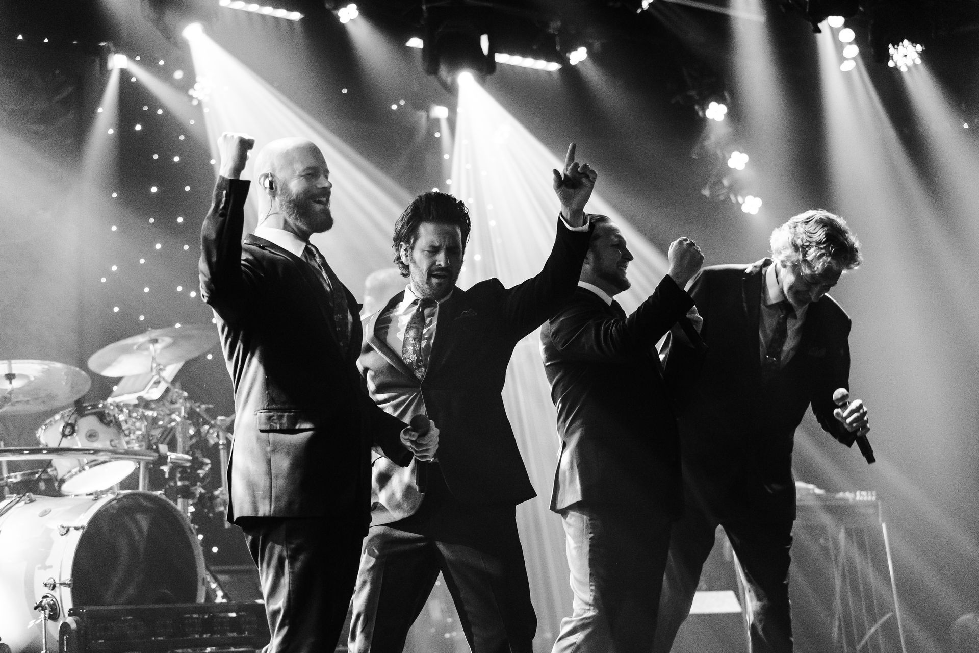 A black and white photo of a group of men on a stage