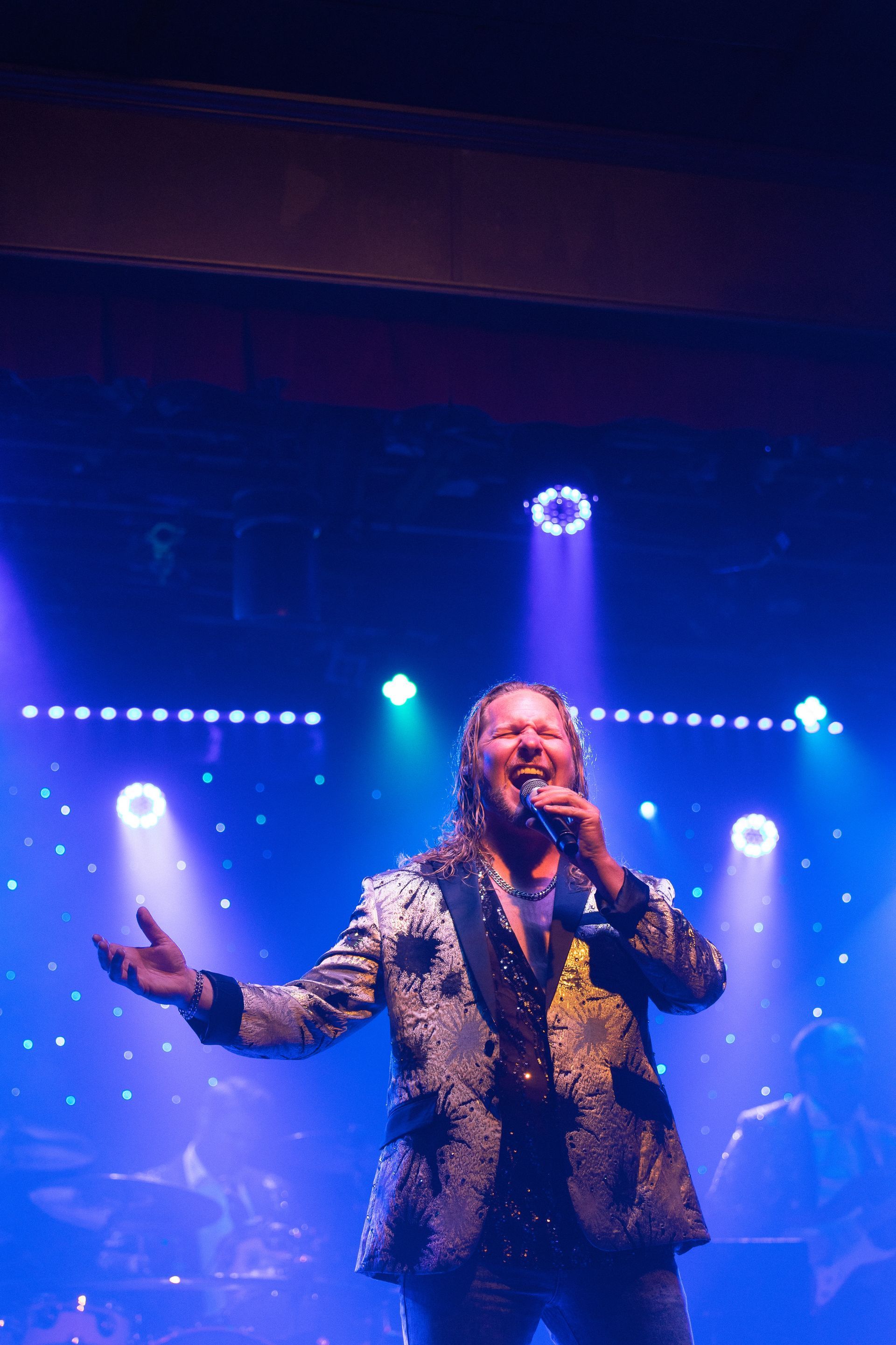 A man singing into a microphone on a stage