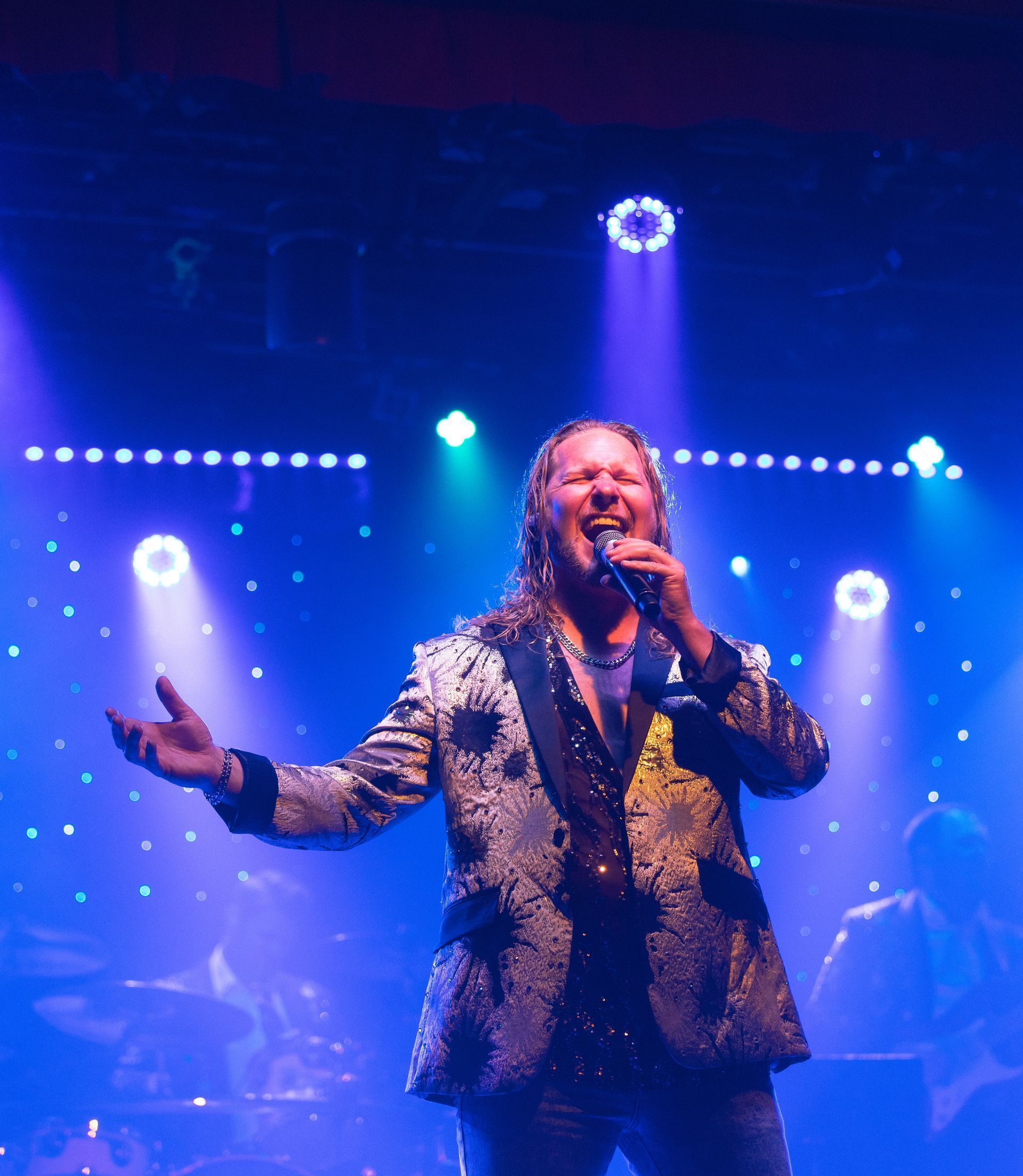 A man singing into a microphone on a stage