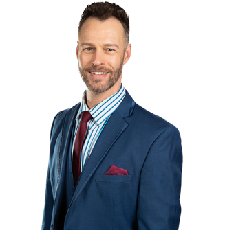 A man in a suit and tie is smiling for the camera