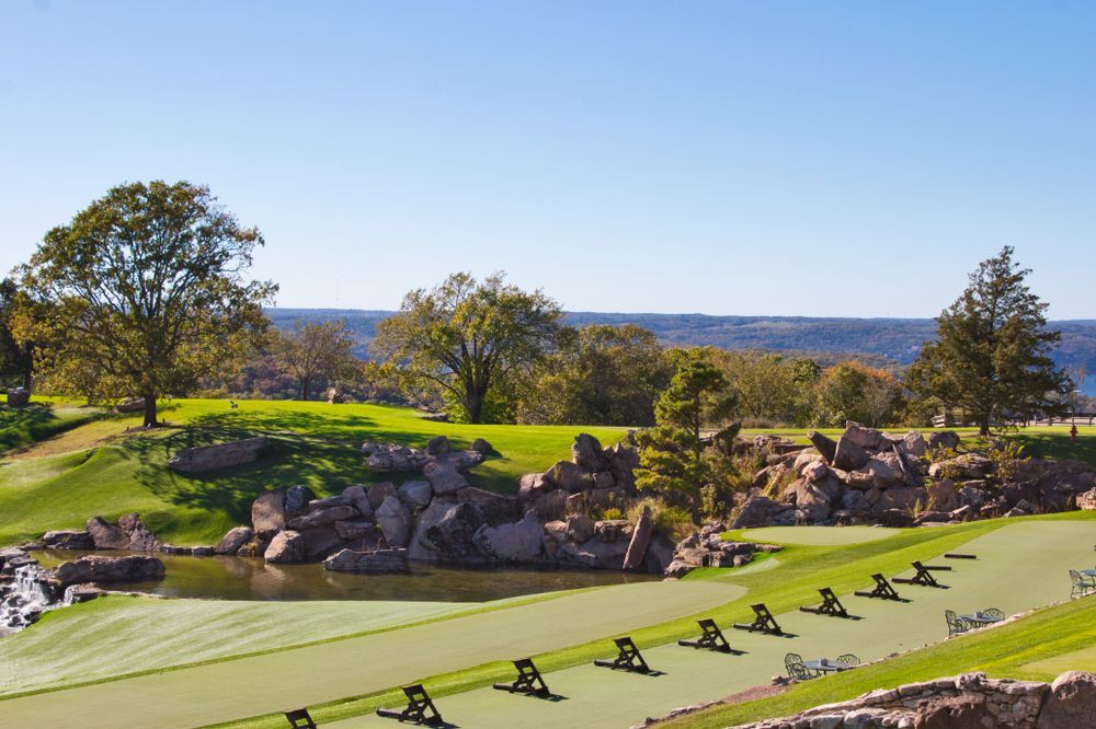 A row of golf clubs are lined up on a golf course.