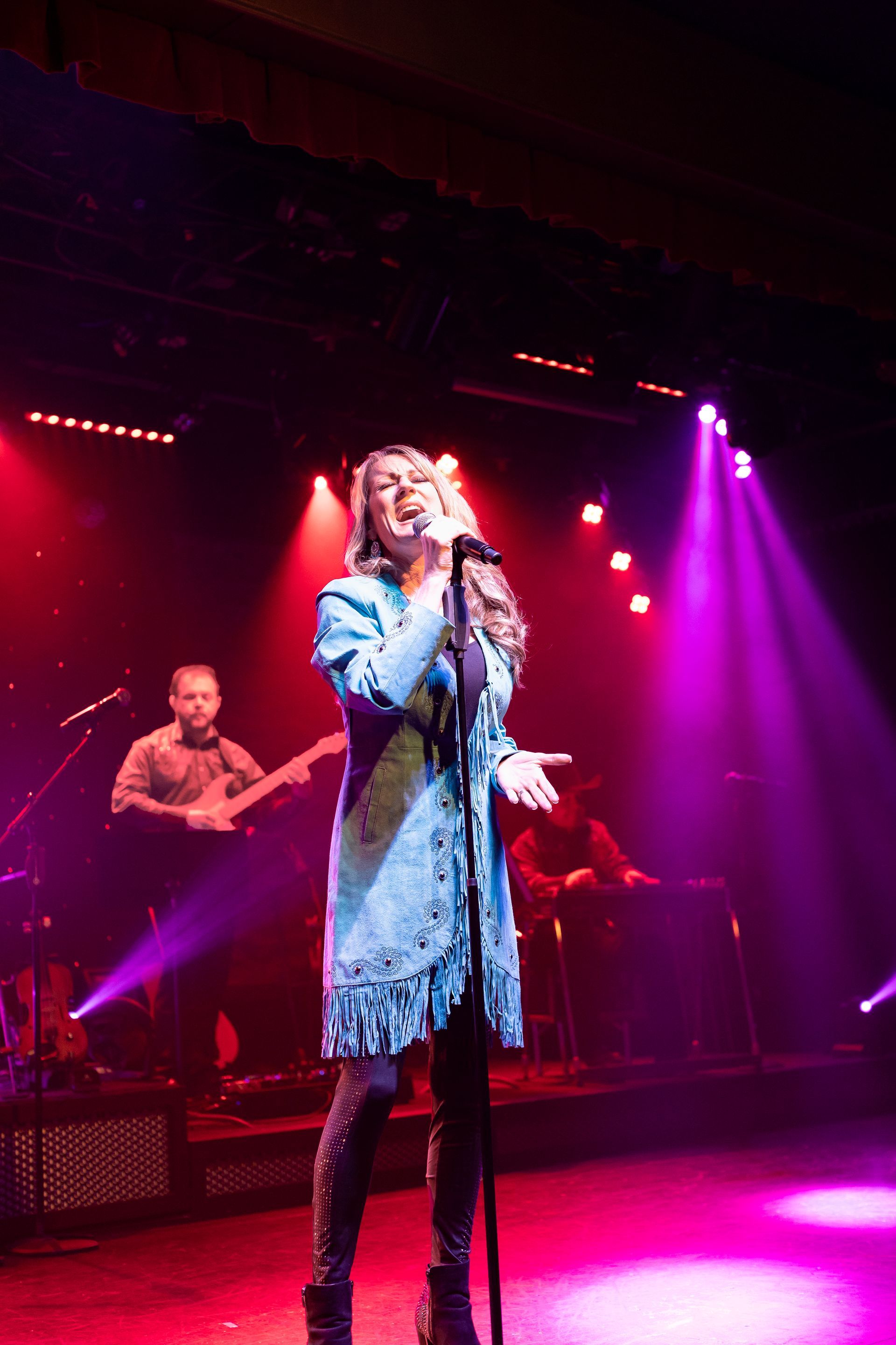 A woman singing into a microphone on a stage