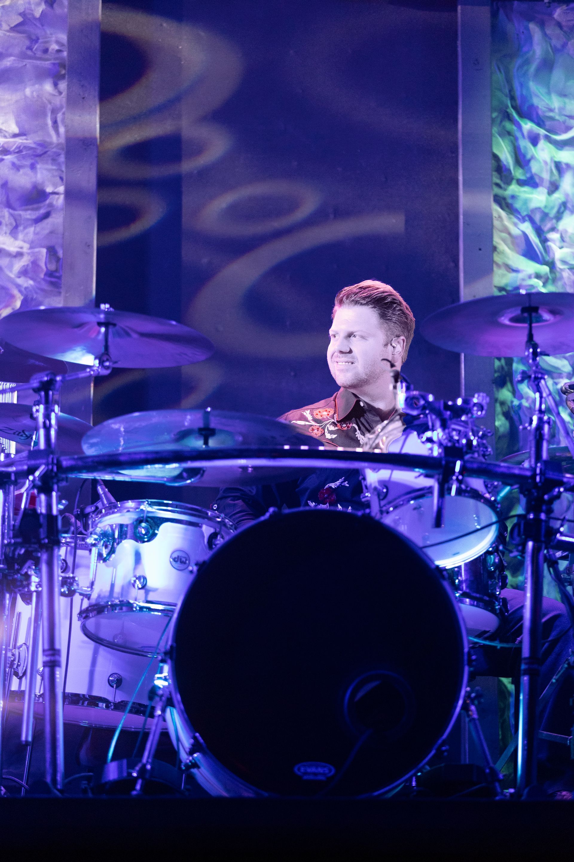 A man is playing drums in a dark room