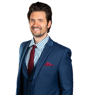 A man in a suit and tie is smiling for the camera