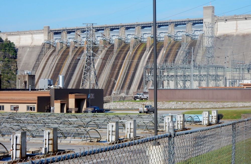 A large dam with a chain link fence in front of it