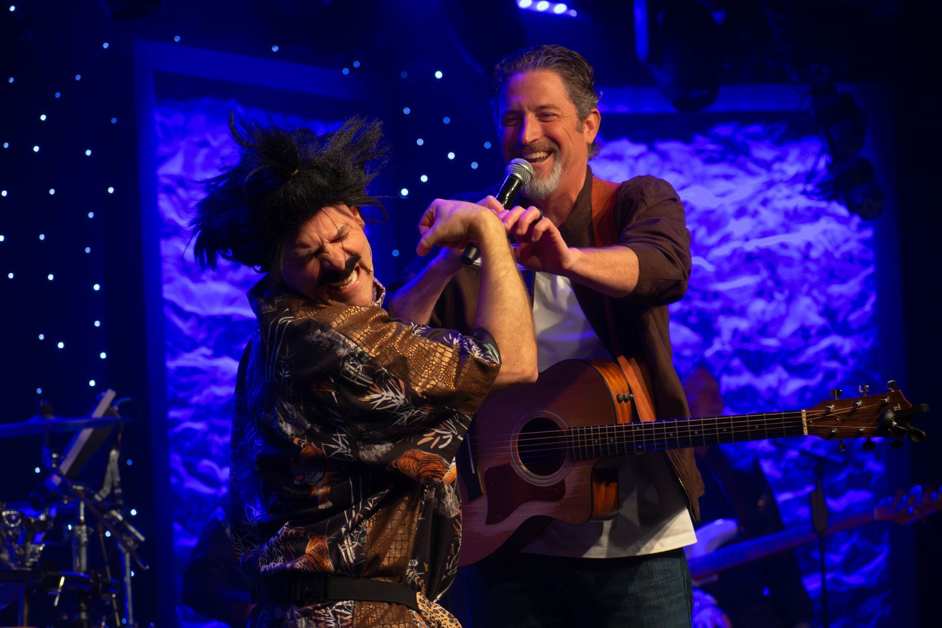A group of people are standing on a stage in front of a piano.