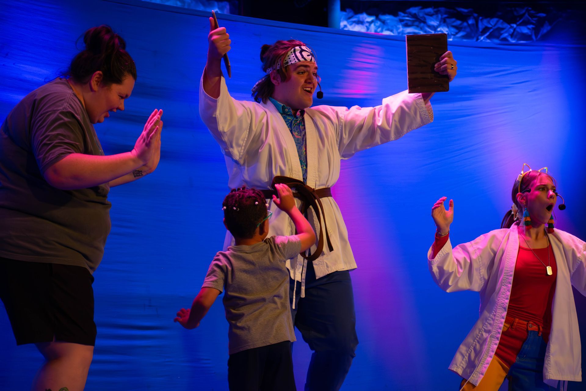 A group of people are standing on a stage in front of a blue background.