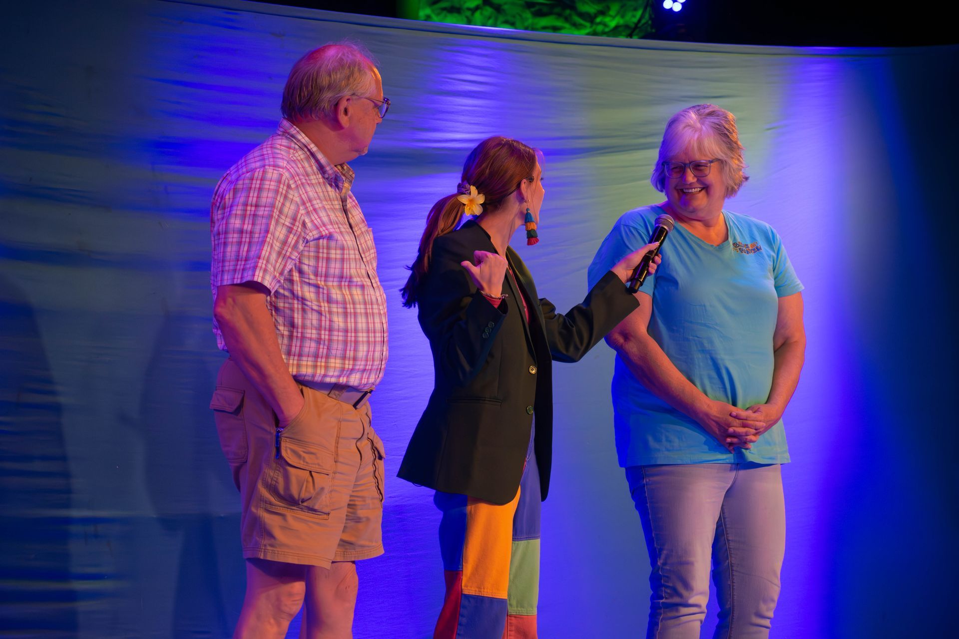 A man and two women are standing next to each other on a stage.