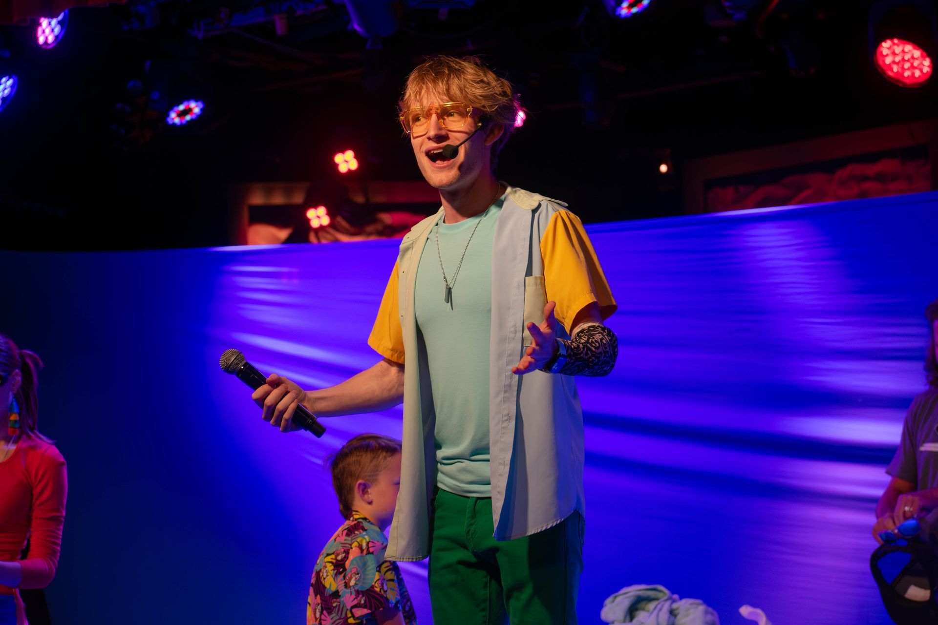 A man is standing on a stage holding a microphone.